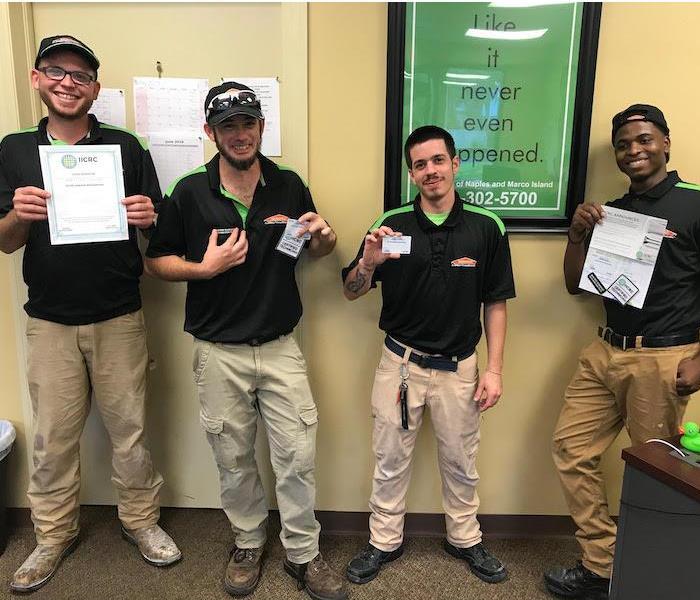 4 SERVPRO employees holding up IICRC water damage restoration certifications