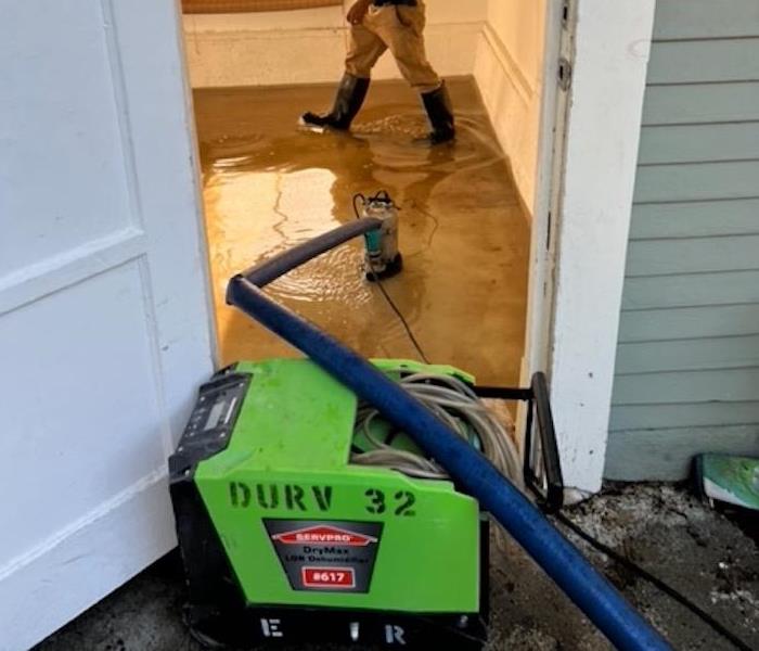 Tech draining floodwaters from a room